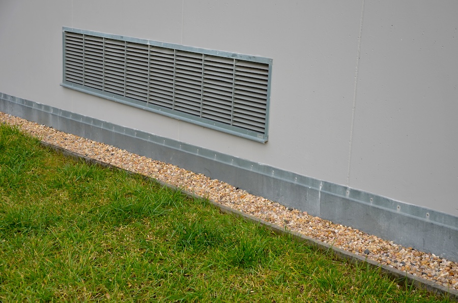 Ventilation grille along the house. basement windows are below ground level.